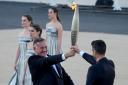 Tony Estanguet, president of Paris 2024, right, receives the Olympic flame from Spyros Capralos, head of Greece’s Olympic Committee, during the flame handover ceremony at the Panathenaic Stadium in Athens (Petros Giannakouris/AP)